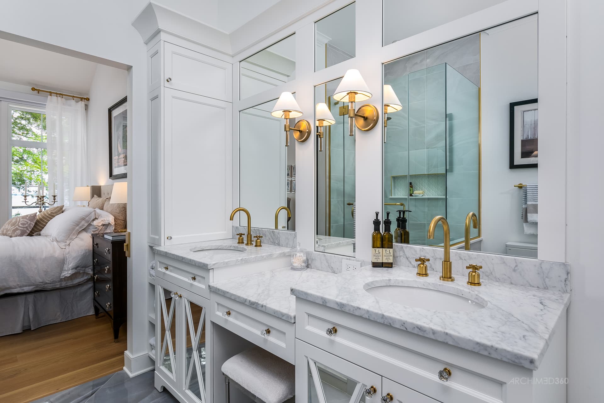 Salle de bain avec comptoirs en marbre et robinetterie en laiton